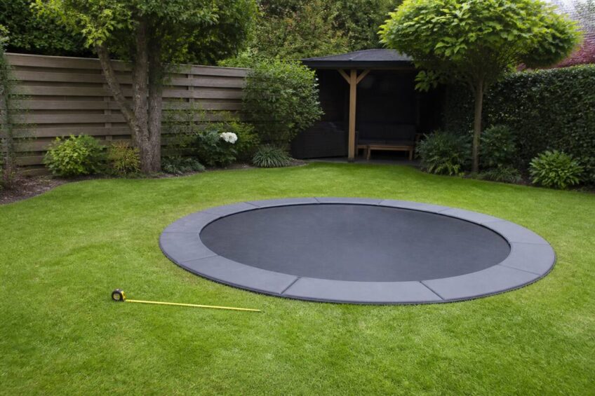 Trampoline in een tuin met meetlint om de juiste maat te bepalen