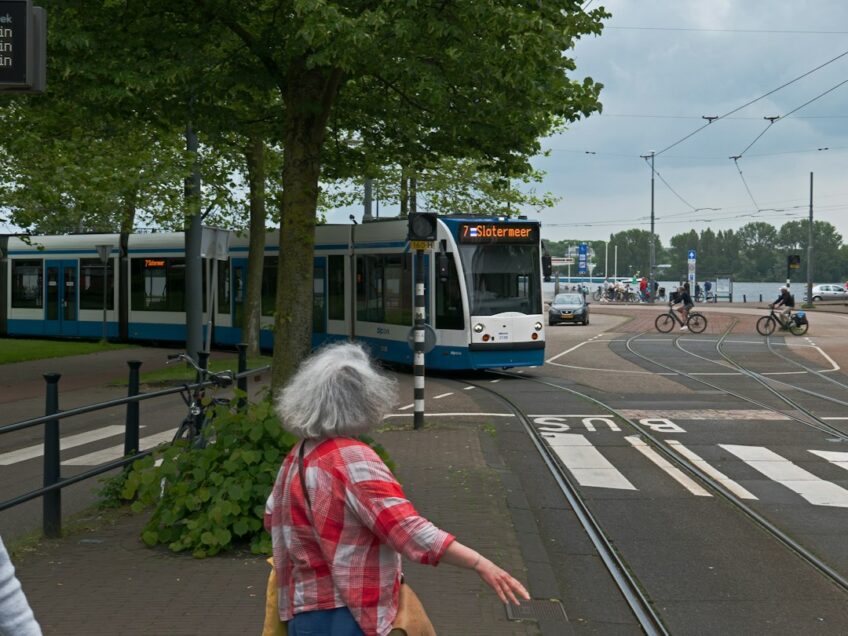a woman is crossing the street in front of a bus